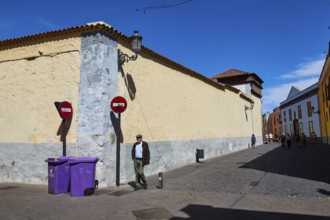 Street scene with man, signs and historic buildings under clear sky, UNESCO World Heritage Old Town