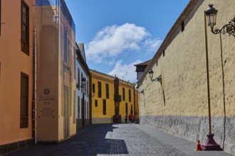 Painted street scene with historic buildings under blue sky, UNESCO World Heritage Old Town of San