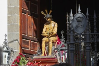 Good Friday procession, Christ statue surrounded by roses in front of a wooden gate, UNESCO World