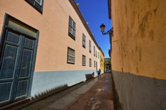 Narrow old town alleyway with pastel-colored houses and decorative alleyway lights, UNESCO World