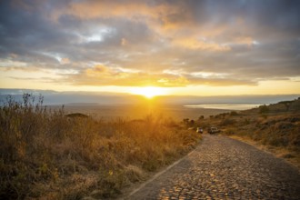 Road leading into Ngorongoro Crater, at sunrise, atmospheric morning light, view of Ngorongoro