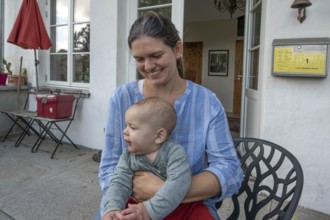 Young mother with her baby on her lap, Mecklenburg-Western Pomerania, Germany