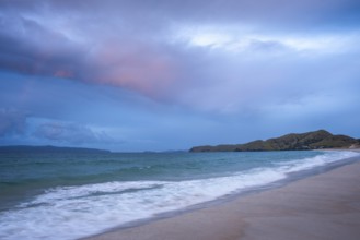 Landscape with sea and sandy beach in New Zealand in the evening at sunset. Otama Beach, Coromandel