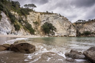 Landscape with sea, sandy beach, rocks and cliffs in New Zealand. Stingray Bay, Coromandel