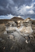 Eroded rock formations in volcanic landscape with dramatic cloudy skies, Ciudad Estratificada or