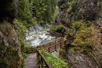 People on wooden walkway on the Diosaz mountain river in the gorge, Gorges de la Diosaz, Les