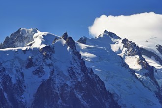 From left snow-covered Mont Blanc du Tacul, Aiguille du Midi, Mont-Blanc in the clouds,