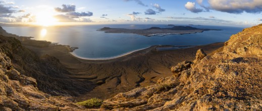 View of steep cliffs to sea and the island of La Graciosa, Mirador del Porrito viewpoint at sunset,