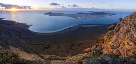 View of steep cliffs to sea and the island of La Graciosa with sun stars, Mirador del Porrito