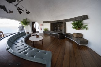 Sitting area with large sofa and fireplace, interior at the Mirador del RÃ­o viewpoint, designed by