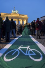 Athena Macke (costume designer) wears a dress with a long train in the shape of a bike path (bike