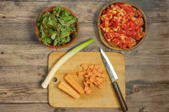 Preparation of fresh vegetables on a wooden cutting board for a healthy salad
