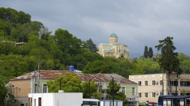 Church on a green hill above city buildings in the foreground, Bagrati Cathedral, Church of the