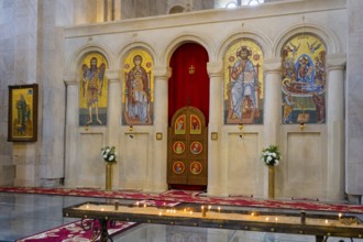 A magnificent church interior with mosaics and icons, candles standing in front of a decorated