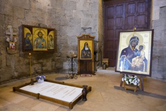 Religious icons and images in an atmospheric church room with burning candles, Bagrati Cathedral,