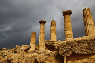Temple of Heracles, Five ancient columns against dark, looming clouds, Valley of the Temples, Valle
