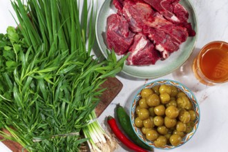 Ingredients for cooking chakapuli, canned tkemali, meat, herbs Georgian cuisine, top view