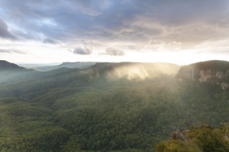 Evening sky with clouds of fog and setting sun at the Three Sisters at Echo Point in Katoomba, Blue