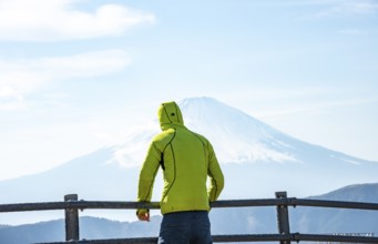 Tourist enjoying the view of the snow-covered summit of Mount Fuji volcano in spring, ÅŒwakudani,