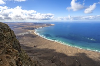 View from the Risco de Famara cliffs to the coast and the sea with the Famara beach, Playa de