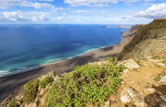 View from the Risco de Famara cliffs to the coast and the sea with the Famara beach, Playa de