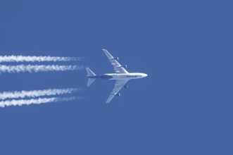 Boeing 747 jumbo jet cargo aircraft of Atlas air airlines flying in a blue sky with contrails or