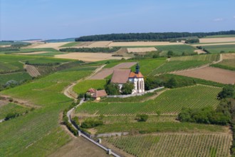 Pilgrimage church Maria im Weingarten, on a hill with surrounding fields under a blue sky, aerial