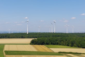 Landscape with several wind turbines on a large, open field under a blue sky, near Volkach, aerial