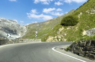 View of the hairpin bend in front with signpost 16th hairpin bend Tornante 2320 metres narrow,