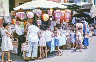 People at busy street market stall in Singapore, southeast Asia, c 1964
