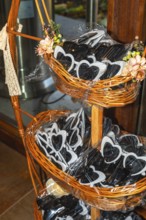 Heart shaped sunglasses are displayed in wicker baskets, adding a playful touch to wedding
