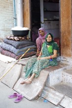 Indian tailors sit next to a tub of cotton in the old city centre, Bundi, Rajasthan, India