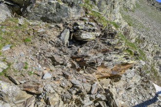 Small pieces of rock eroded rock lying open on mountainside of rocky peak in Alps, Italy