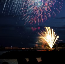 Brightly shining atmospheric fireworks for the Helgoland island festival in red, blue and gold over