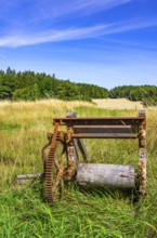 Traditional historical and rusty weathered agricultural equipment in a rural setting near