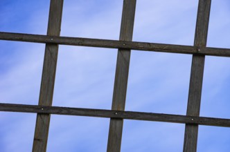 Wooden lattice against a blue sky, detail of a wing of a traditional windmill near the village of