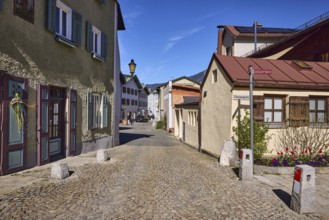 Historic houses, lantern, facade, windows, doors, alleyway, cobblestones, bollards, blue sky,