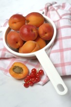 Apricots in a colander and redcurrants