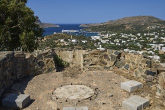 Base of an anti-aircraft battery, overlooking a village and the sea, surrounded by dry vegetation,