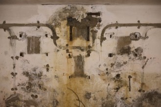 Lost Place, Ruin of a barracks, Dilapidated wall with old pipes and visible traces of weathering,