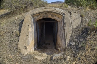 Dilapidated bunker entrance in nature, leading into the darkness, Italian air defence position,
