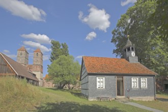 Parish hall with slate wall, spire and Romanesque St. Mary's Collegiate Church, church ruins,