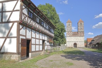 Half-timbered house and Romanesque St Mary's Collegiate Church with twin towers, church ruins,