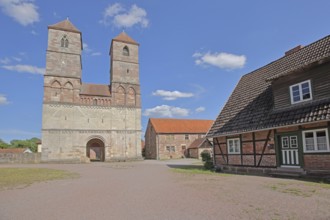Romanesque St Mary's Collegiate Church with twin towers and half-timbered house, brick building,