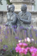 Bronze sculpture at the market fountain, modern art, male figure, female figure, couple, sitting,