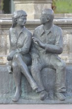 Bronze sculpture at the market fountain, modern art, male figure, female figure, couple, sitting,