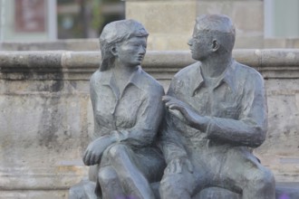 Bronze sculpture at the market fountain, modern art, male figure, female figure, couple, sitting,
