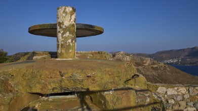 A weathered concrete platform on a hill with a sweeping sea view in a barren landscape, Lost Place,