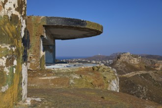 A dilapidated concrete bunker on a hill overlooking the coastal landscape, Lost Place, Lago