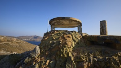 Derelict bunker structure on a hill with sea and mountains in the background, Lost Place, Lago